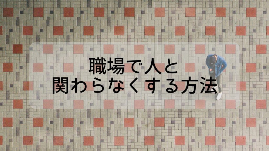 広い空間に1人で立って携帯を見ている帽子を被った男性