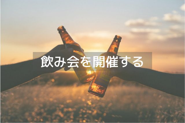 太陽の前で瓶のお酒を乾杯する2人