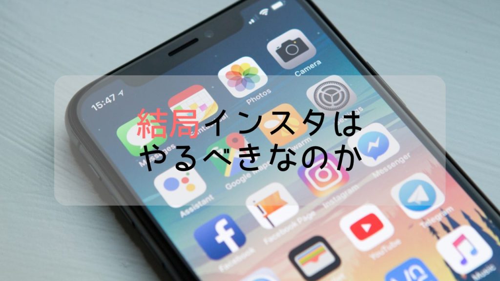 SNSのアプリが羅列されたホーム画面が開かれた状態でiphoneが置かれている。