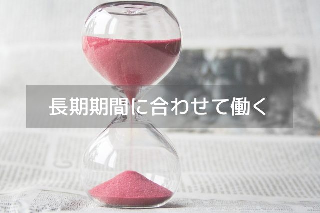 机の上に置かれたピンク色の砂が入った砂時計