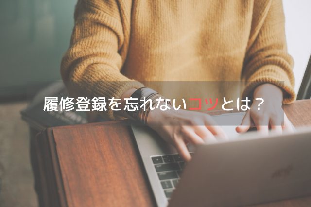 黄色のカーディガンを着た人が机の上でMacで作業している