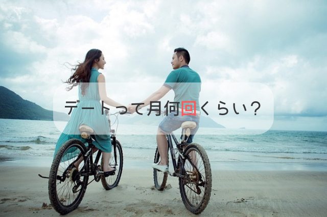 海で男女が自転車に乗りながら手を繋ぎ顔を見合わせている