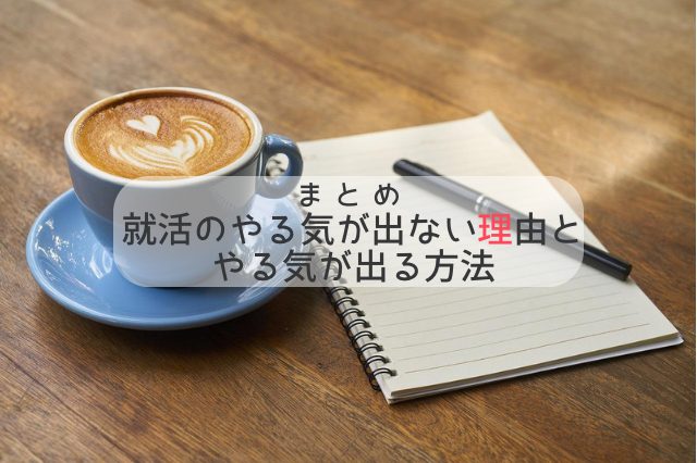 カフェラテとノートとペンが木の机の上に置かれている